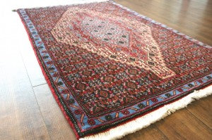 全体が赤く青い縁のあるペルシャ絨毯(コルデスタン産)